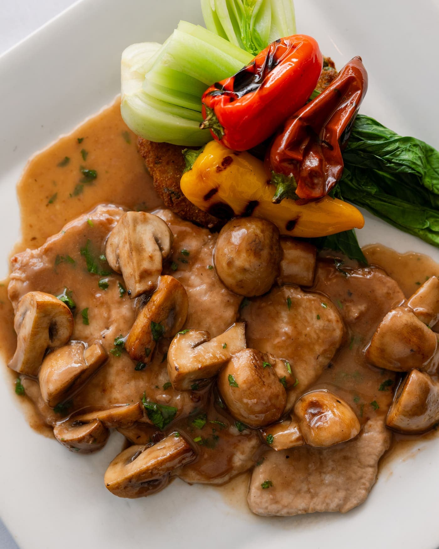 Escalopes de veau en sauce aux champignons, poivrons grillés et bok choy