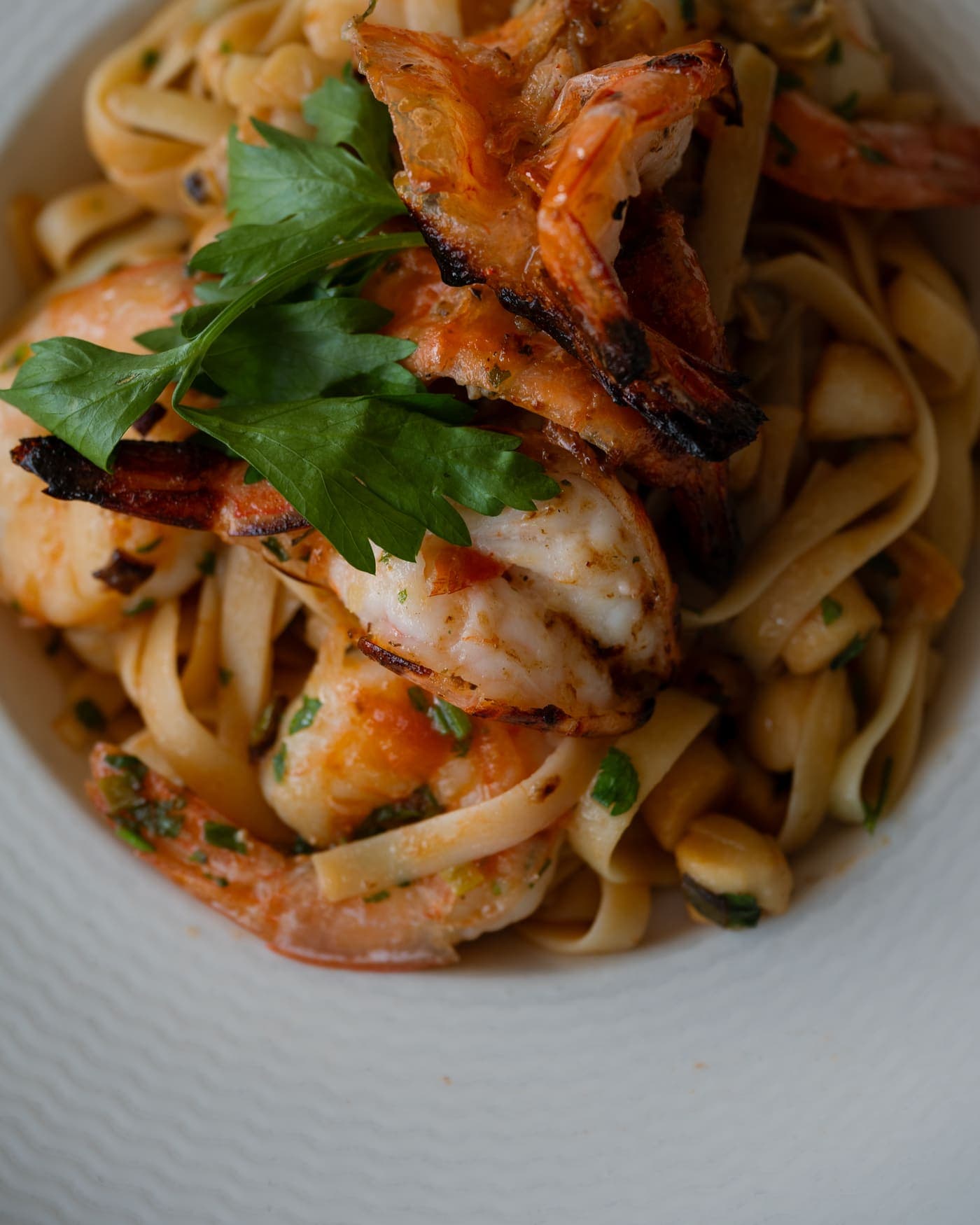 Fettuccine garnies de crevettes grillées et de persil frais